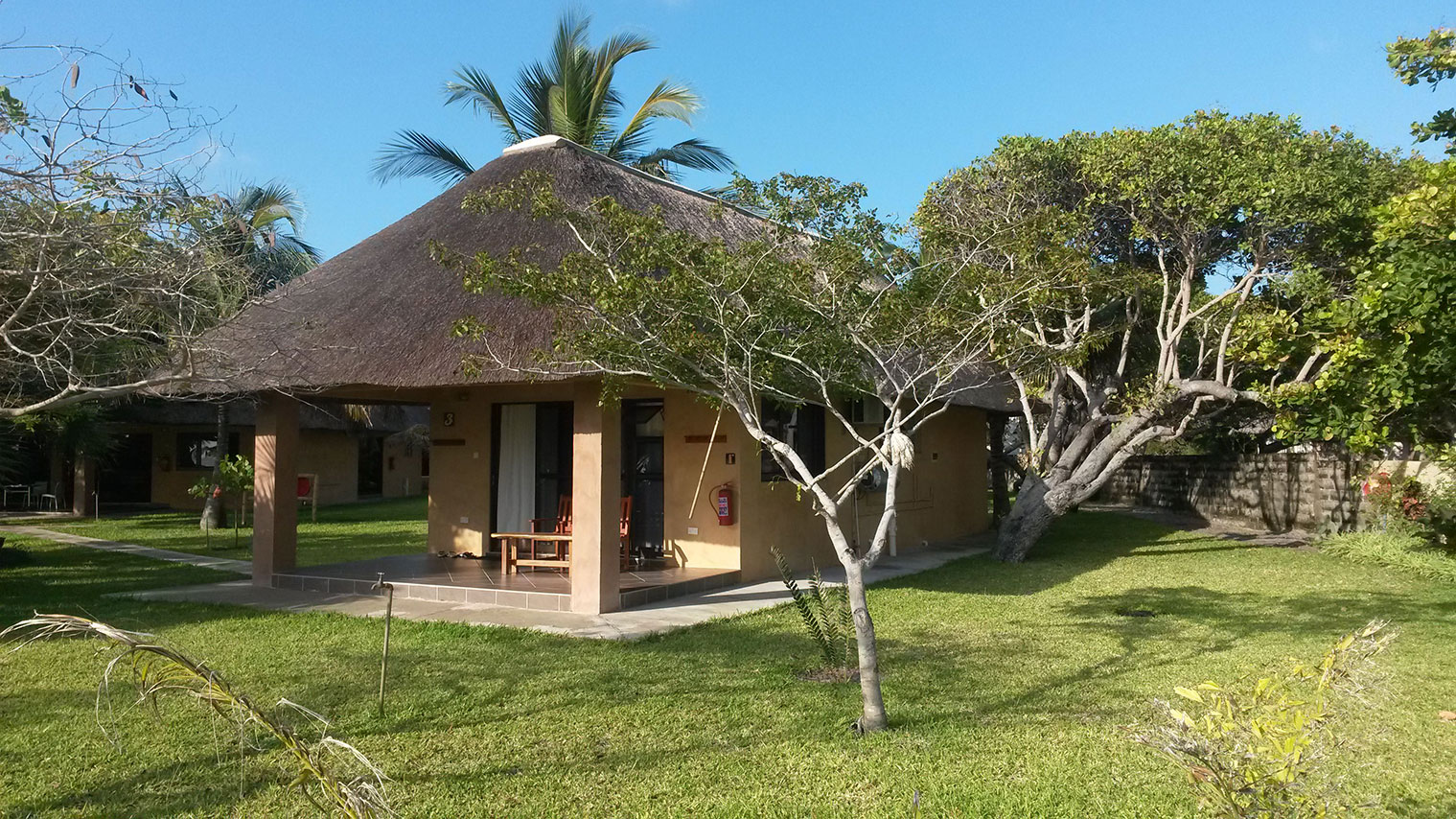 Freestanding thatched villa set among tropical gardens